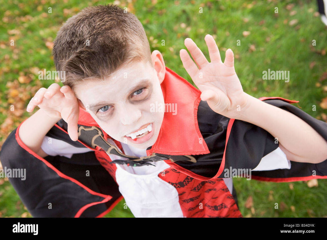 Young boy outdoors wearing vampire costume on Halloween Stock Photo