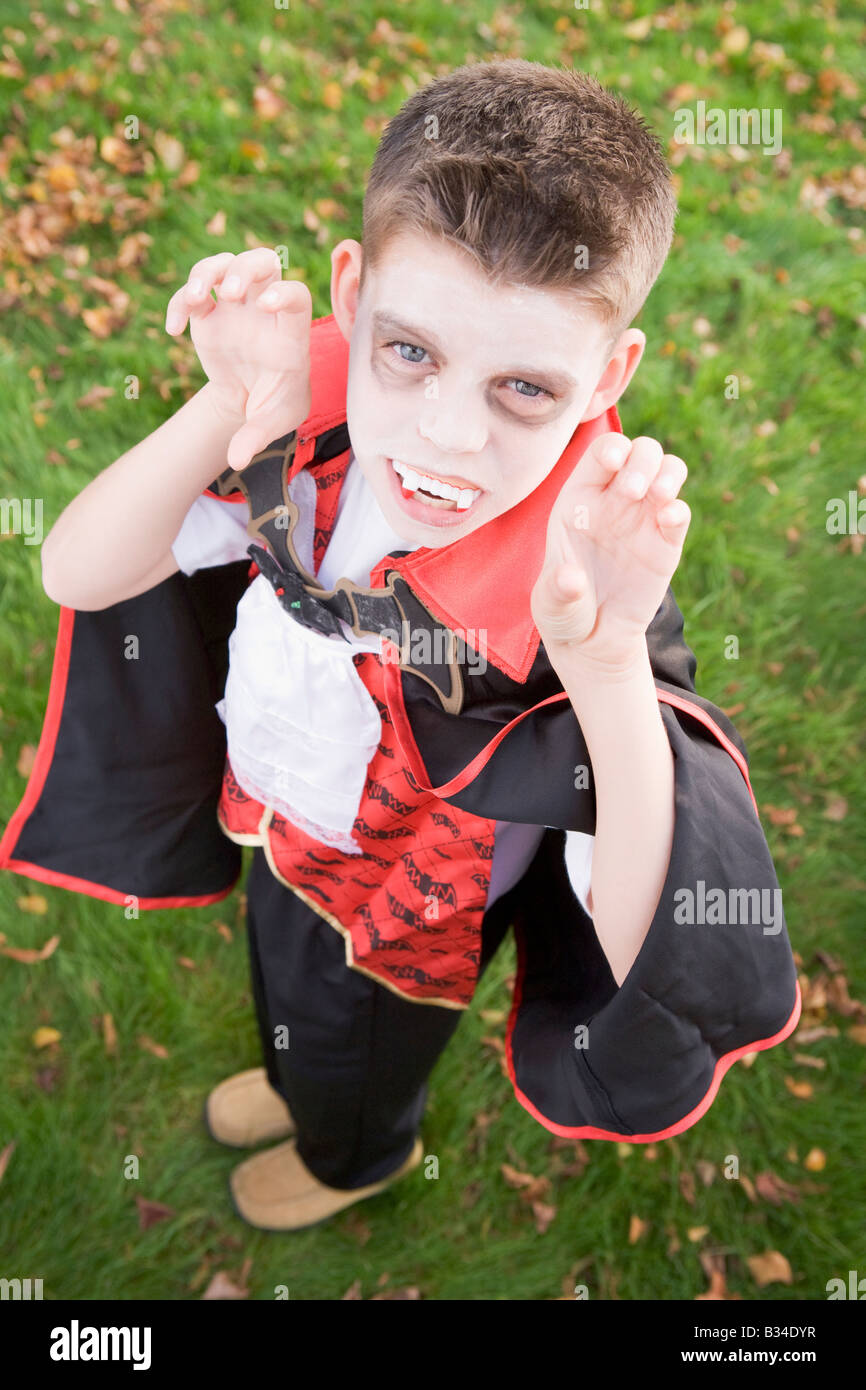 Young boy outdoors wearing vampire costume on Halloween Stock Photo