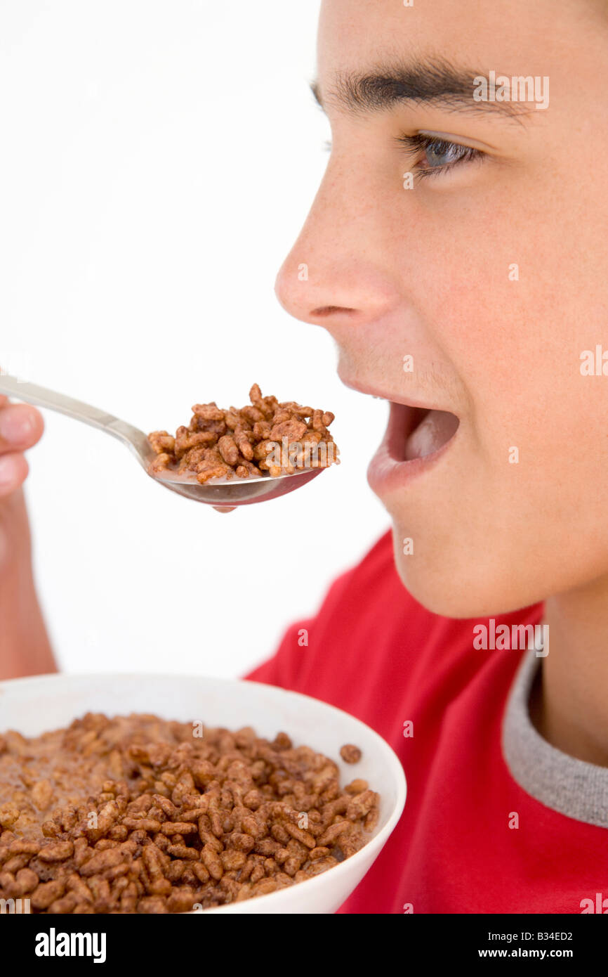 Boy eating chocolate puff cereal Stock Photo