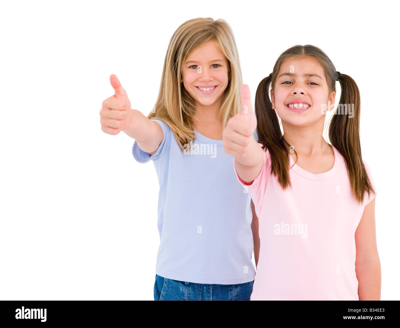 Two girl friends giving thumbs up smiling Stock Photo