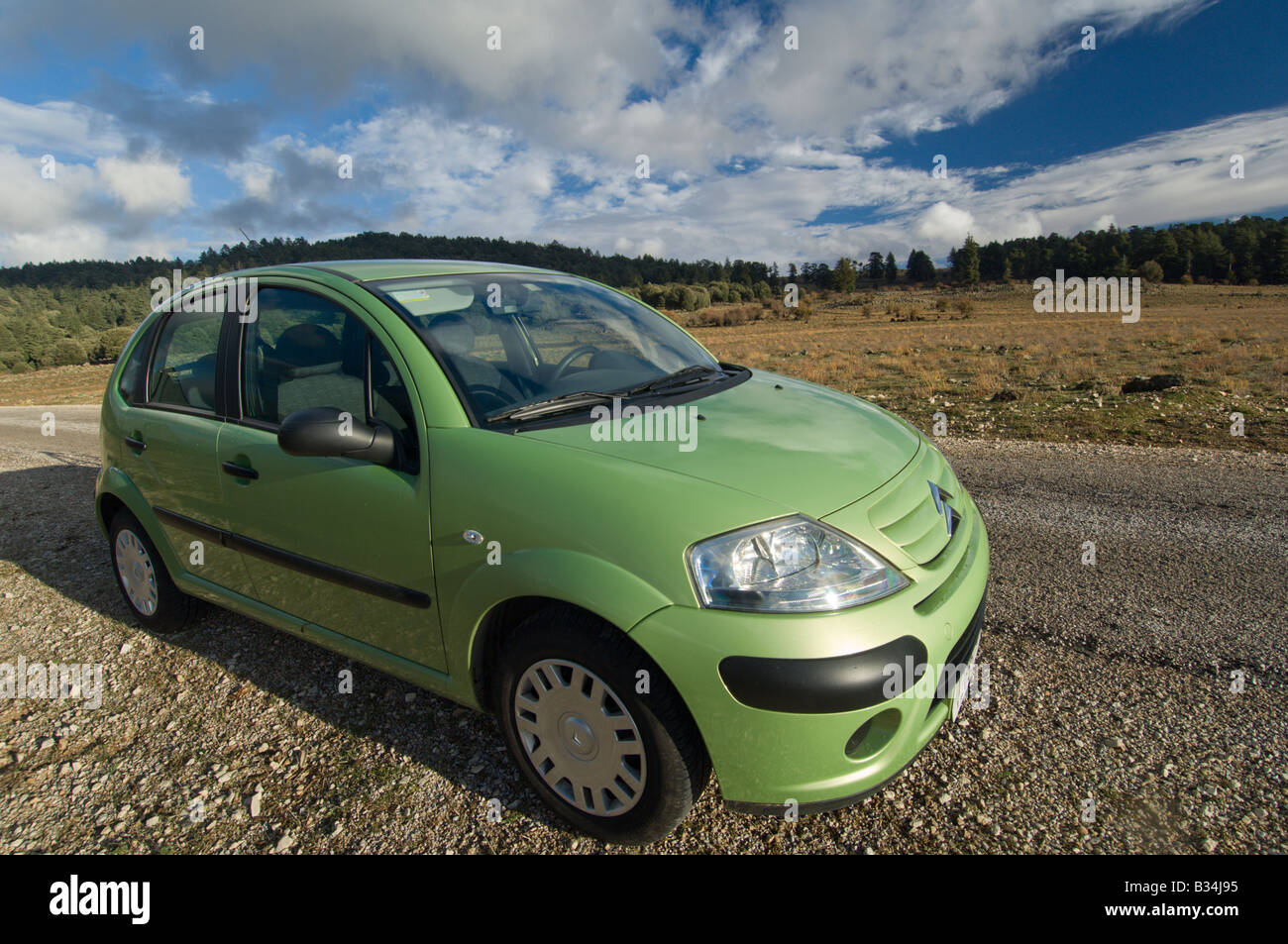Small green European car in a wide landscape, Morocco Stock Photo