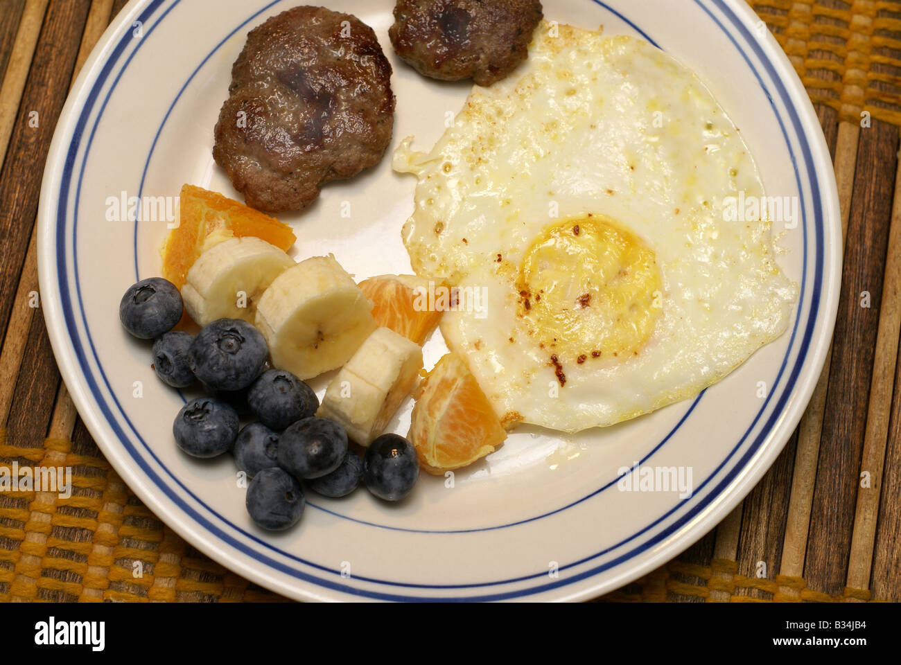 Fried Egg, Sausage and fruit Stock Photo