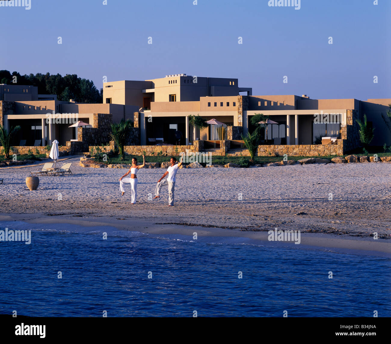Greece, Halkidiki, Porto Sani. Yoga on beach in front of the Asterias Suites Stock Photo