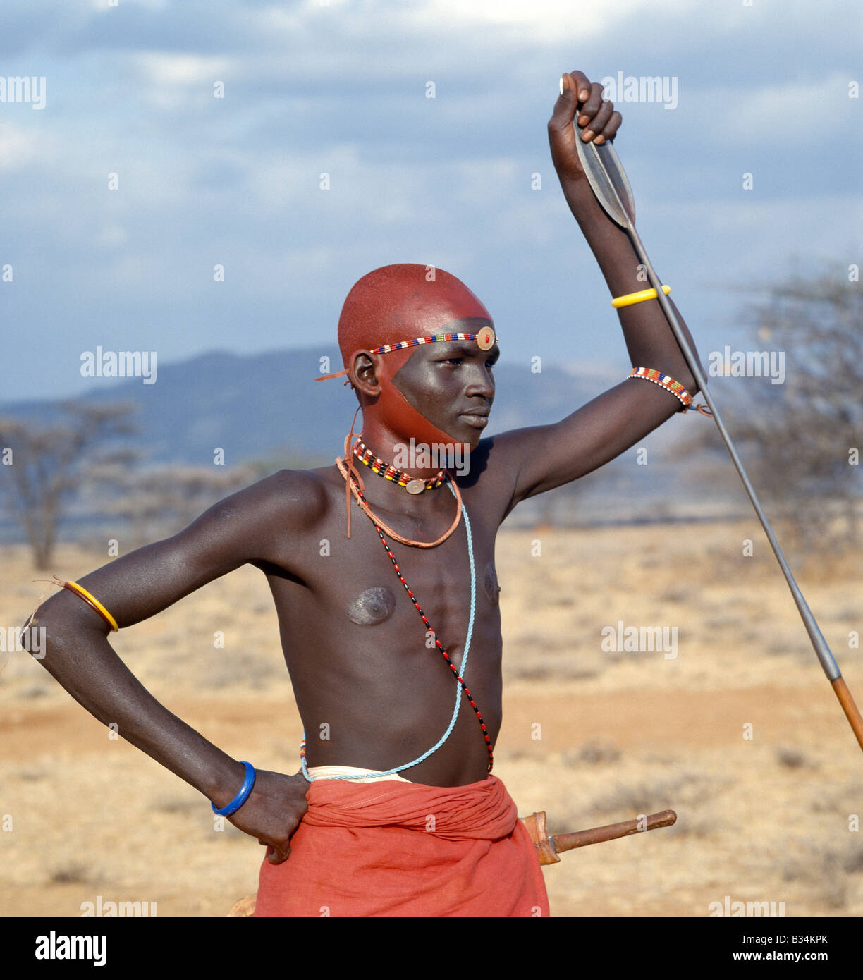 Kenya, Samburu District, Wamba. Immediately an initiate completes his lmuget loolbaa ceremony (the ceremony of the arrows) a month after his circumcision, he becomes a junior warrior of the Samburu tribe. From wearing a drab black cloak and carrying a bow and arrows, he proudly dons the ochred finery of a warrior, spear in hand. Overnight, he is transformed from a boy into a man, confident of his new role in tribal affairs. Stock Photo