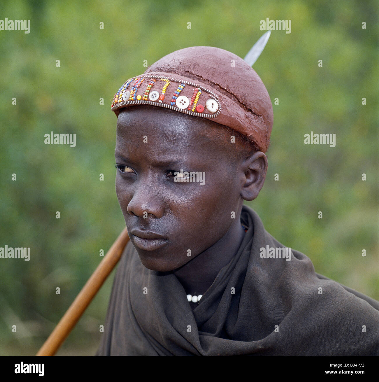 Kenya, Baringo, Churo. A Pokot youth has his hair styled with Ochred clay and decorated with beads and buttons to denote his recent circumcision. Stock Photo