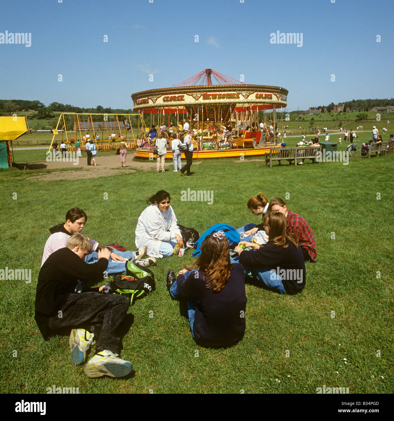 UK England County Durham Beamish Open Air Museum children relaxing on grass at the fairground Stock Photo