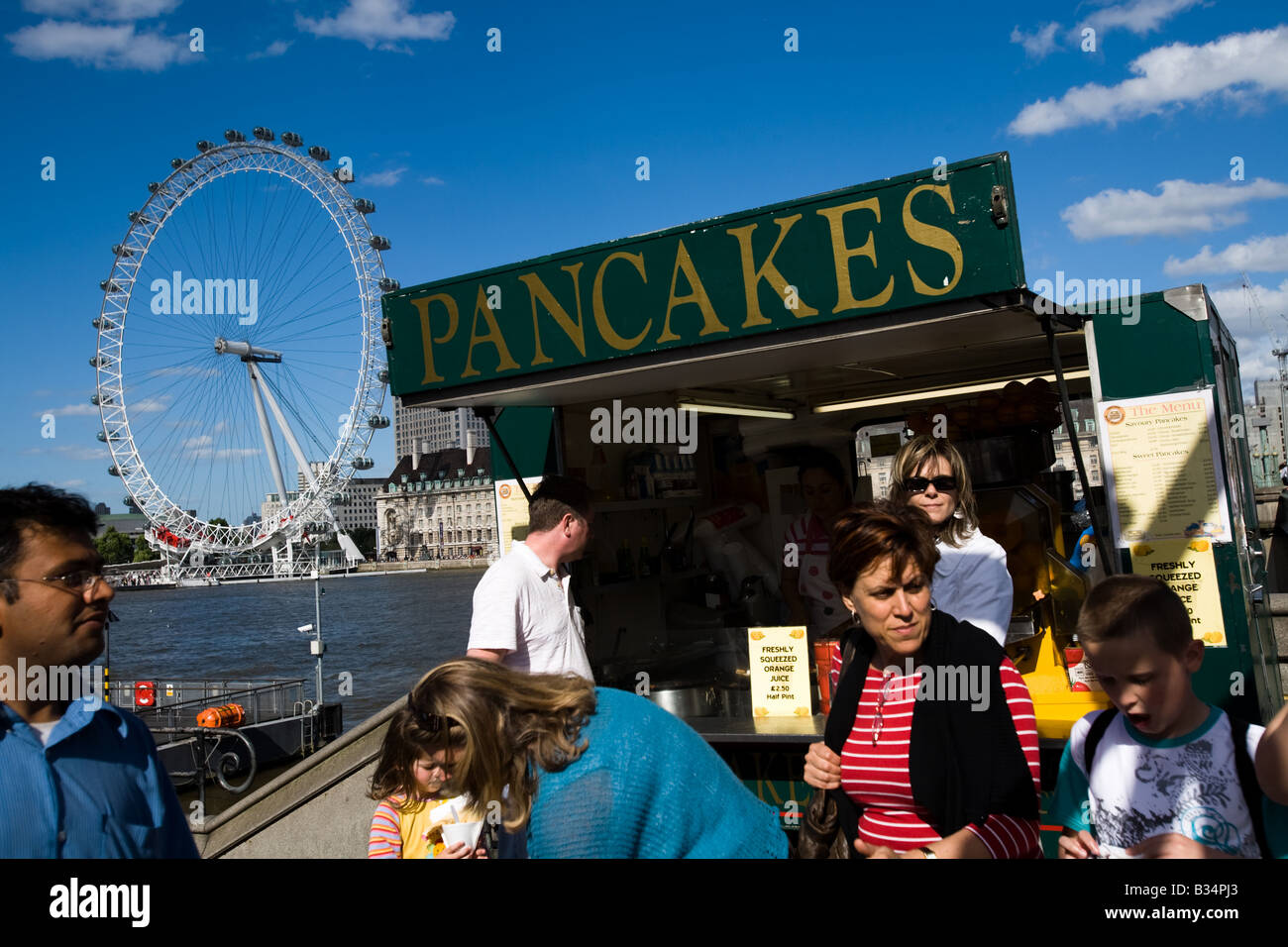 People stand by a pancake stand near the London Eye in London, UK Stock