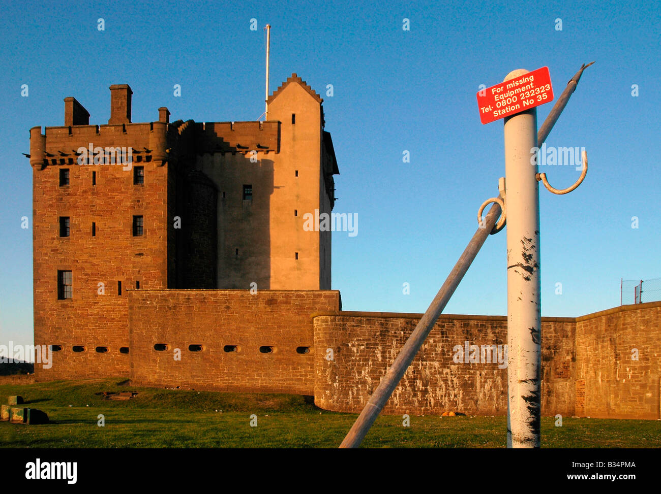 Broughty Ferry castle with a signpost of information about claiming lost equipment fished up from the sea. Stock Photo