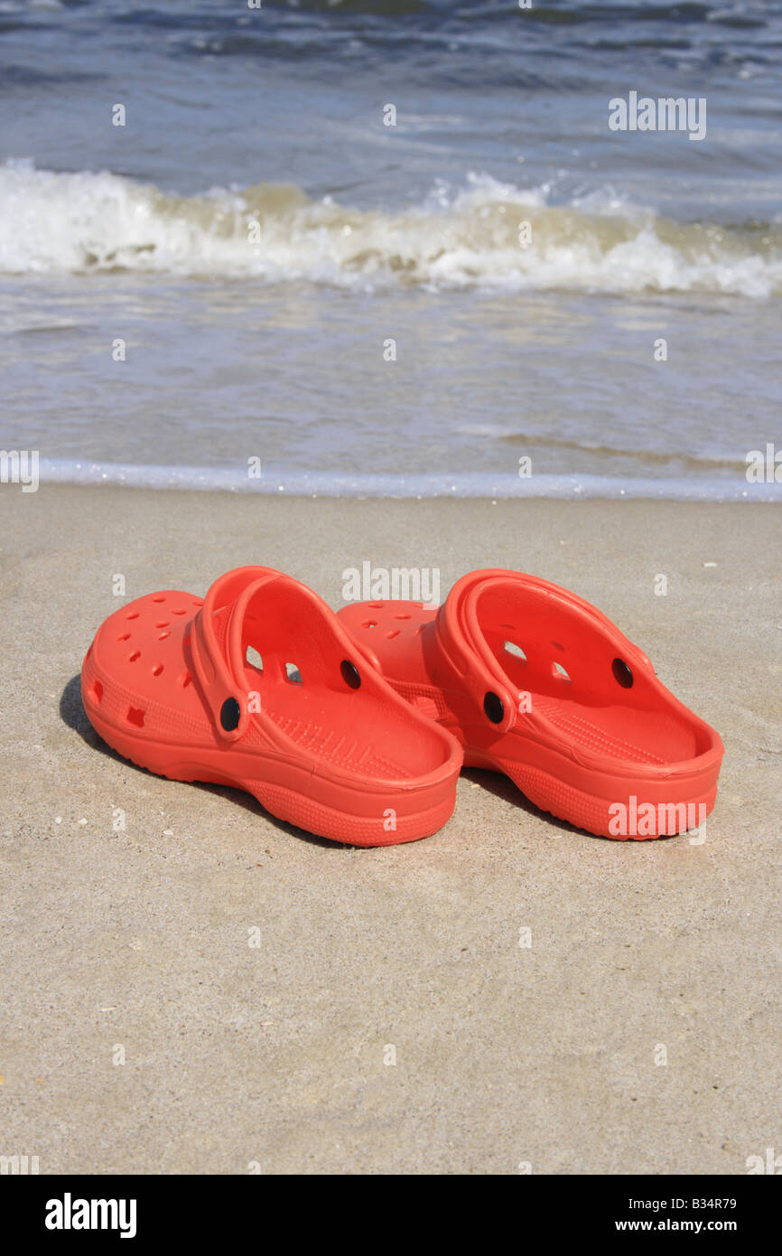 pair of red crocs at the sandy beach. Photo by Willy Matheisl Stock ...