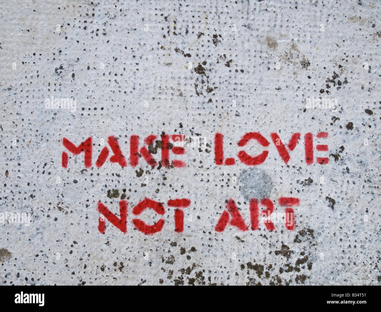 MAKE LOVE, NOT ART written on stone. Stock Photo