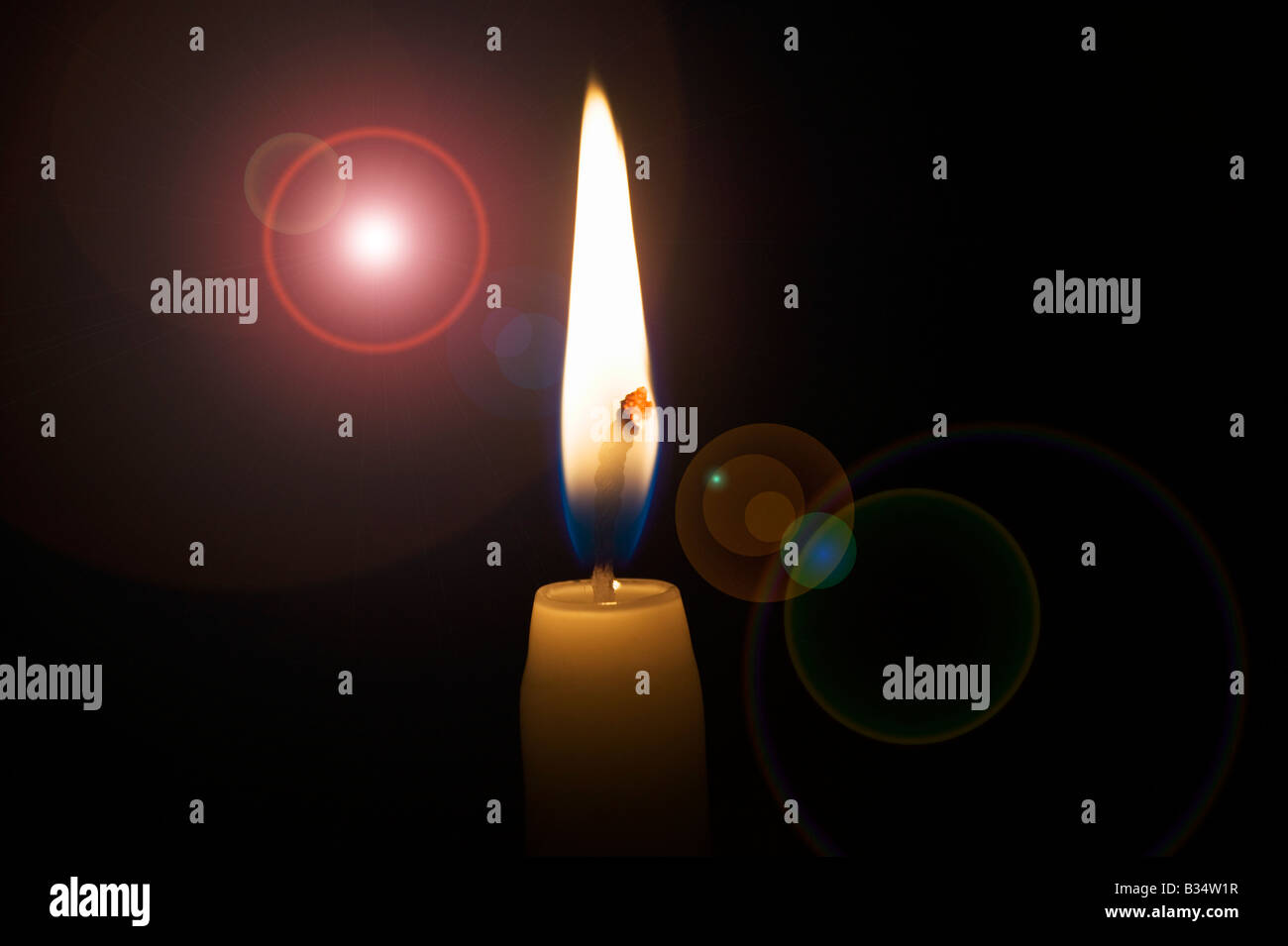 Lighted candle and lens flare against black Stock Photo Alamy