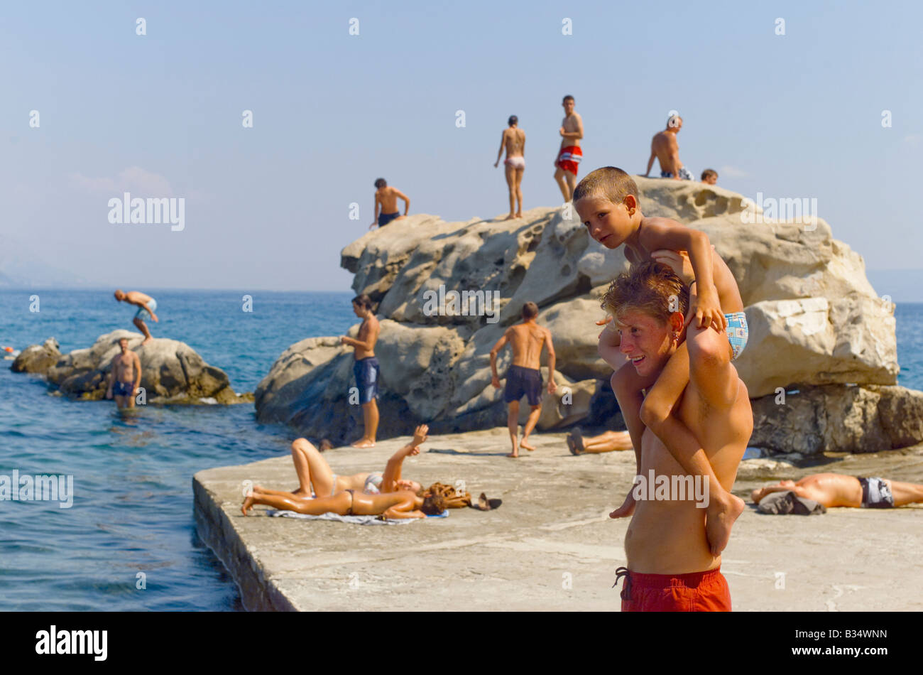 Father carries his on on shoulders Family bathing at Split city beach Croatia Stock Photo