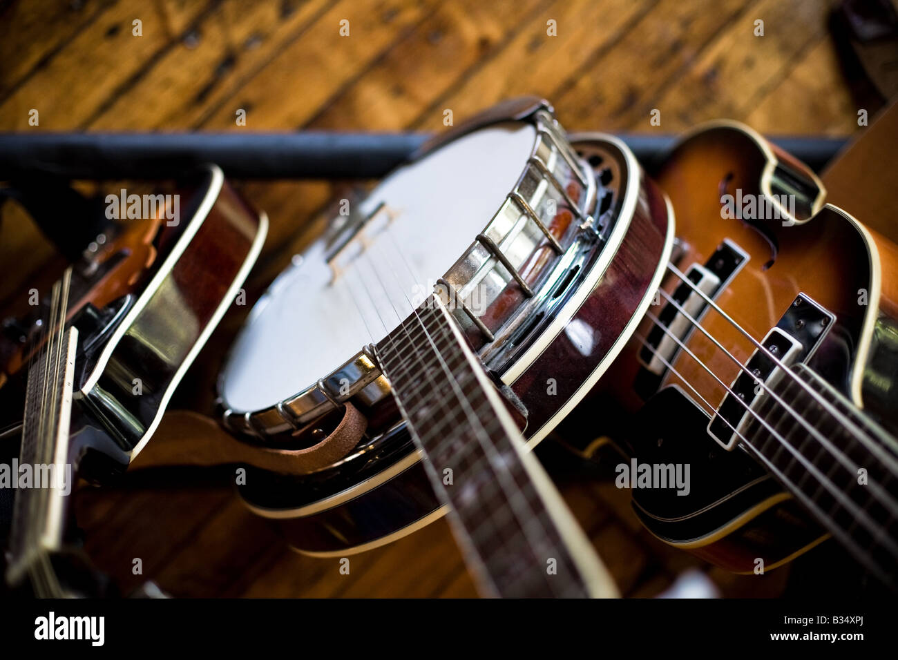 A banjo, mandolin, and bass guitar sit propped in a stand waiting their