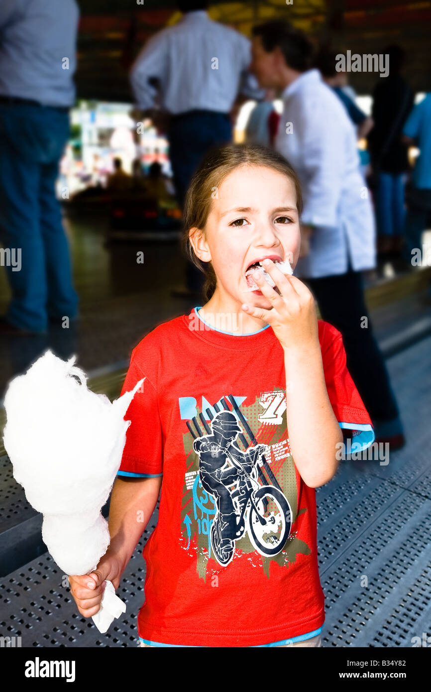 Young girl eating cotton candy on kermis Stock Photo