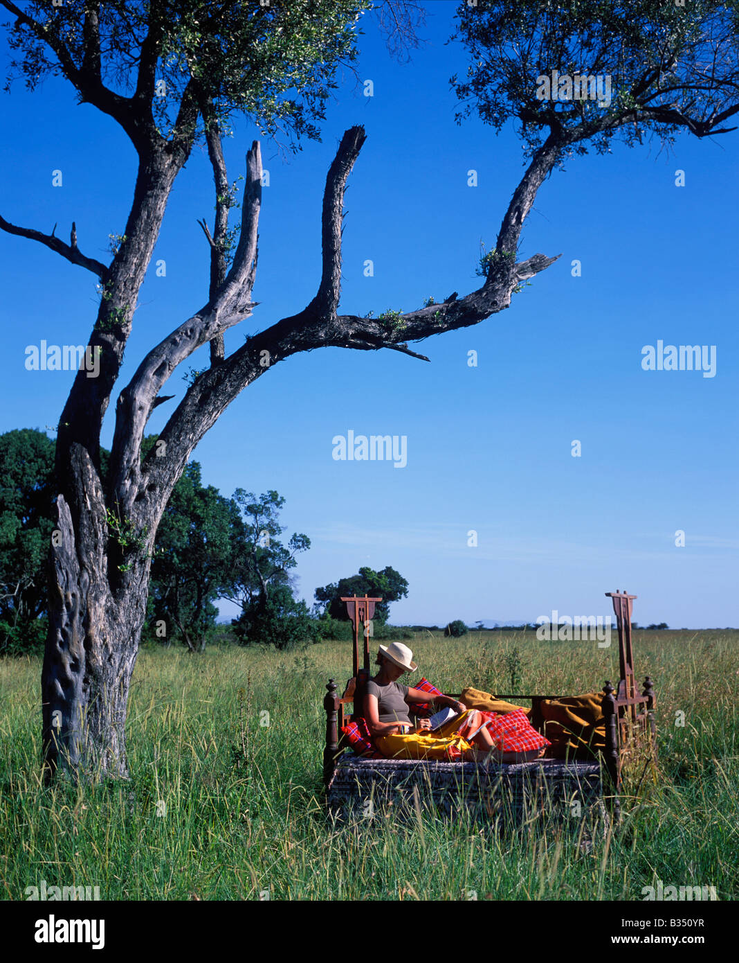Kenya, Masai Mara. Bush style, relaxing in a Lamu bed at Cheli & Peacock's Mara Camp Stock Photo