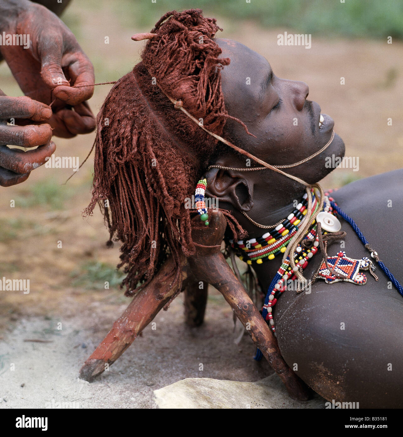 Kenya, Maralal, Lodokejek. A Samburu warrior has his Ochred hair braided by a friend. Stock Photo