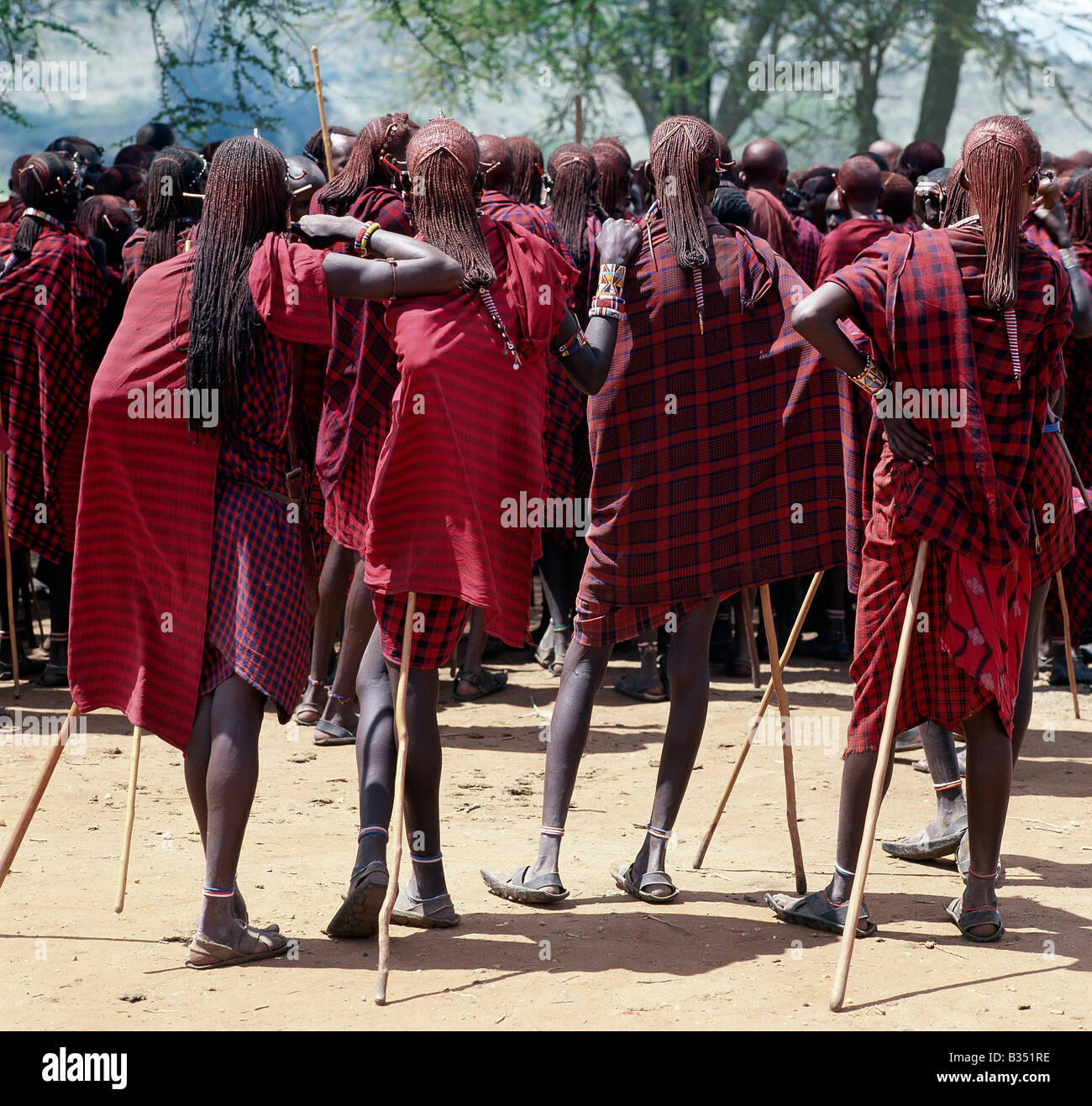 Kenya, Kajiado, IIbisil. Maasai warriors resplendent with long ochred braids relax and wait for the start of a ceremony. Red has always been their preferred colour. Stock Photo