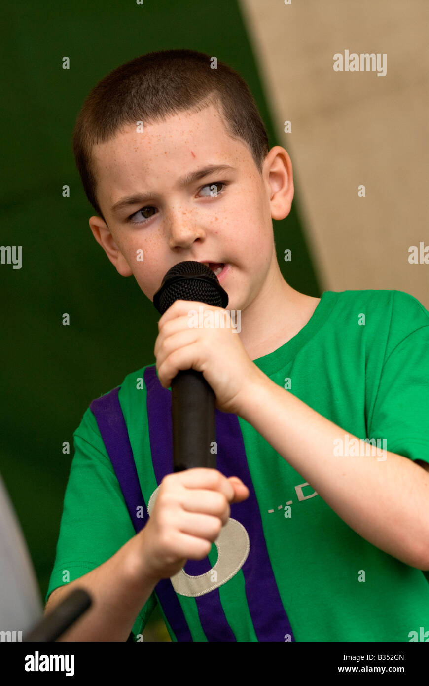 Young boy taking part in karaoke session at a housing estate fun day, North Kensington, London, UK. Stock Photo