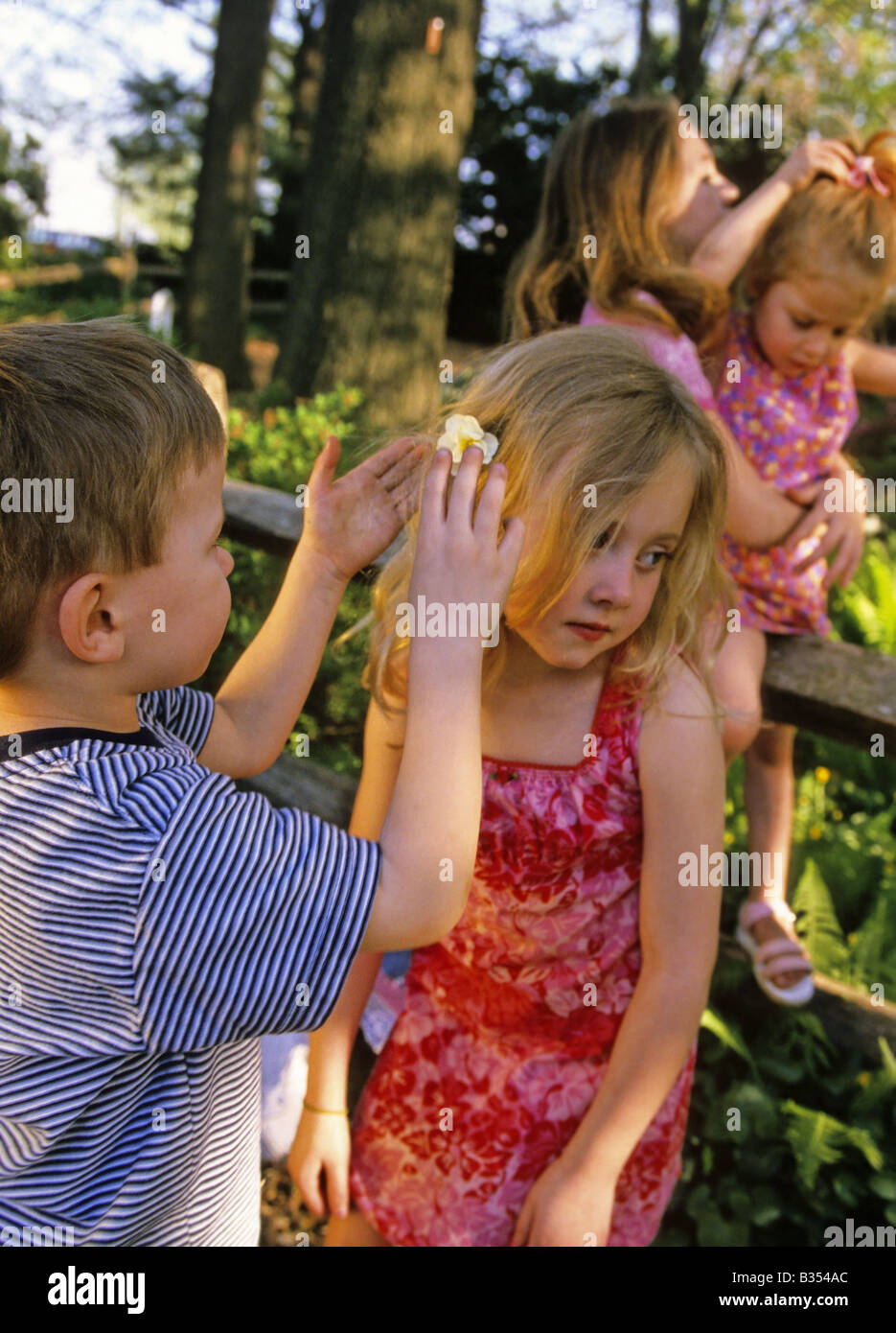 Boy puts flower in girl s hair Stock Photo Alamy
