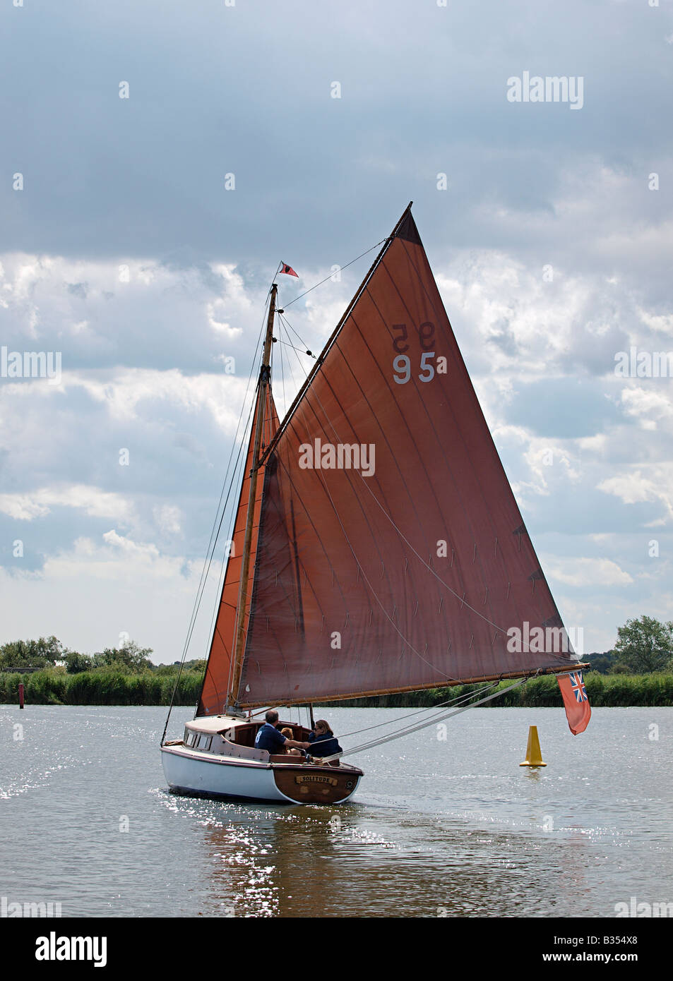 RIVER CLASS CRUISER CALLED SOLITUDE  WITH SAIL NUMBER 95  SAILING ON RIVER THURNE NORFOLK BROADS ENGLAND UK Stock Photo