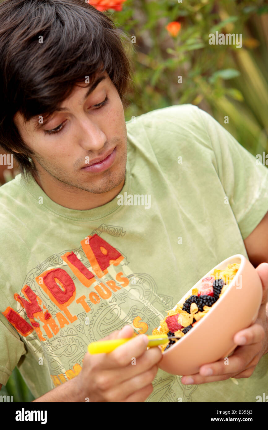 Young Man Eating Cornflakes with Berries Model Released Stock Photo