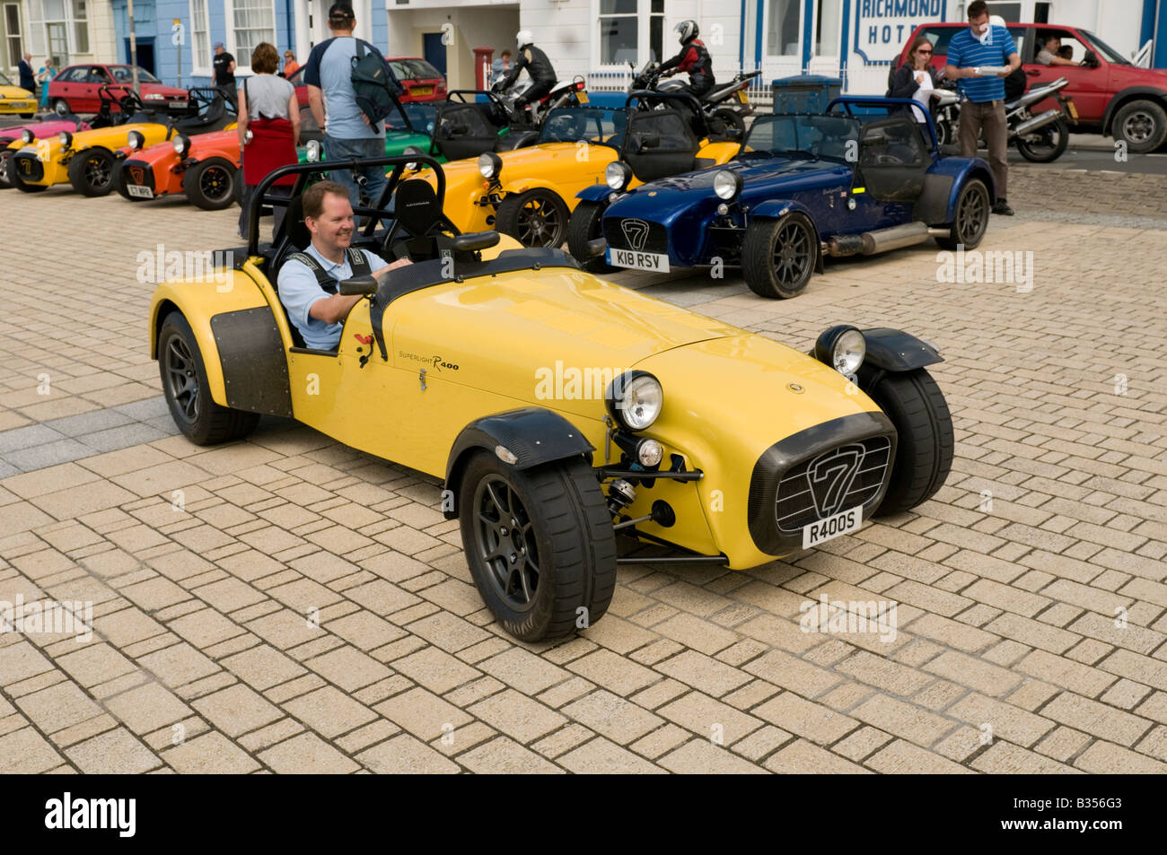man driving Lotus Caterham 7 classic british motor car supporters club rally on the promenade in Aberystwyth Wales UK Stock Photo