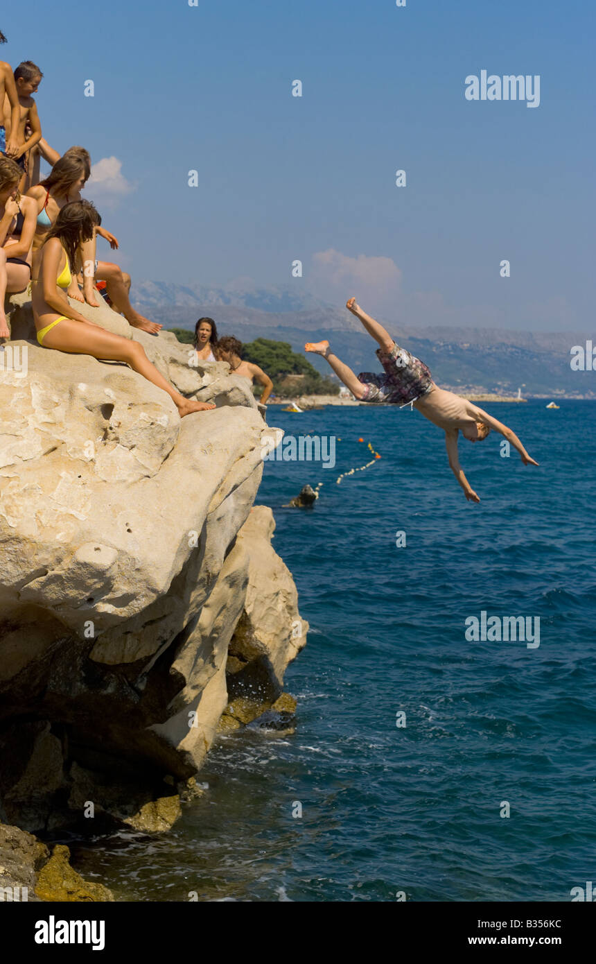 Young Croatian swimmers dive off rocks at Split City beach Croatia Stock Photo