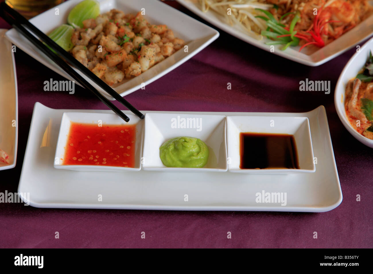 Thai Food Dip Sauces Deep Fried Squid Szechuan Duck Stir Fried fresh vegetables dish in a restaurant setting Stock Photo