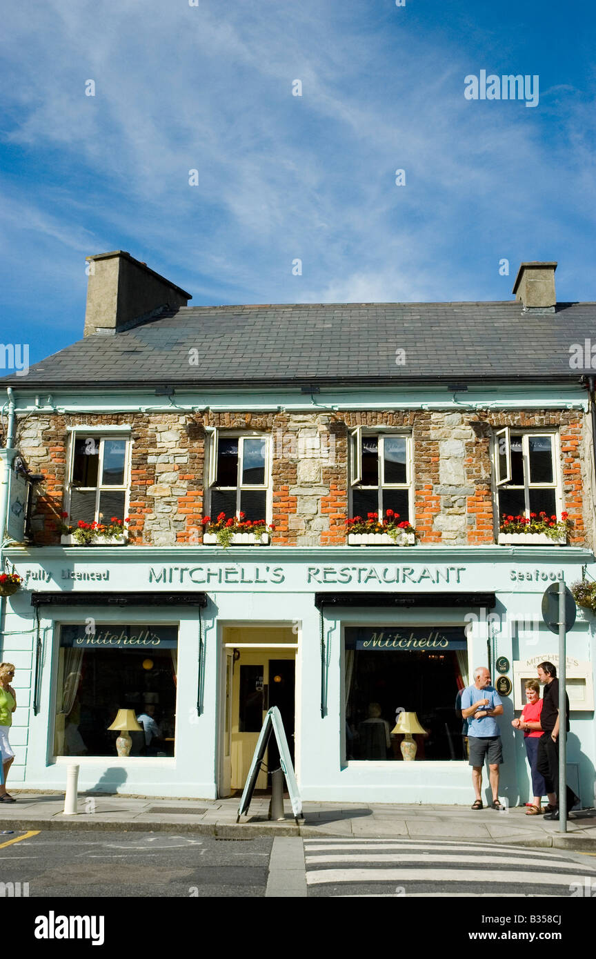 People look at the menu in the window of a restaurant in the town centre of Clifden, Connemara
