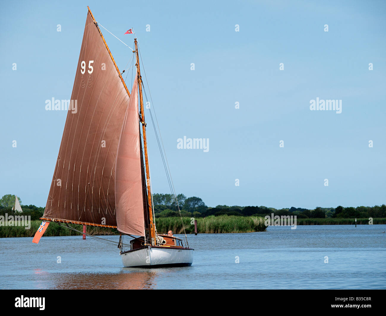 RIVER CLASS CRUISER CALLED SOLITUDE  WITH SAIL NUMBER 95  SAILING ON RIVER THURNE NORFOLK BROADS ENGLAND UK Stock Photo