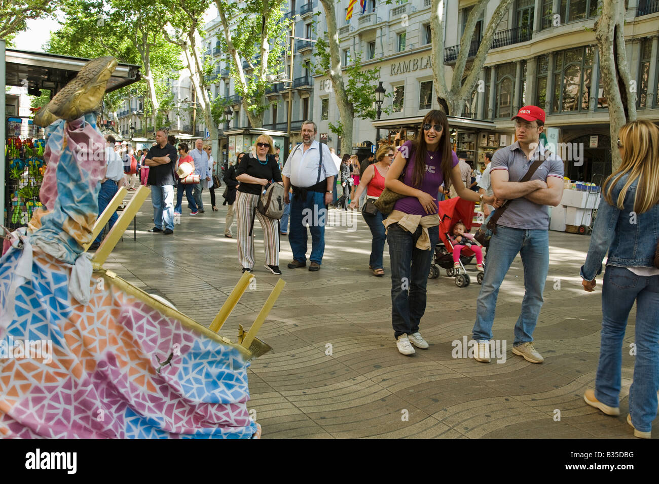 SPAIN Barcelona Crowd of people walk down Las Ramblas and watch performance artists Stock Photo