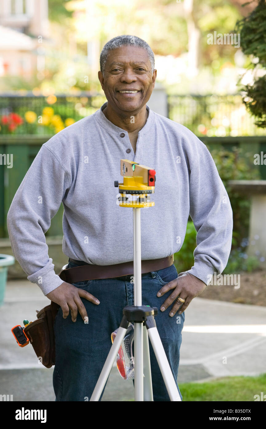 African American man using a laser level Stock Photo - Alamy