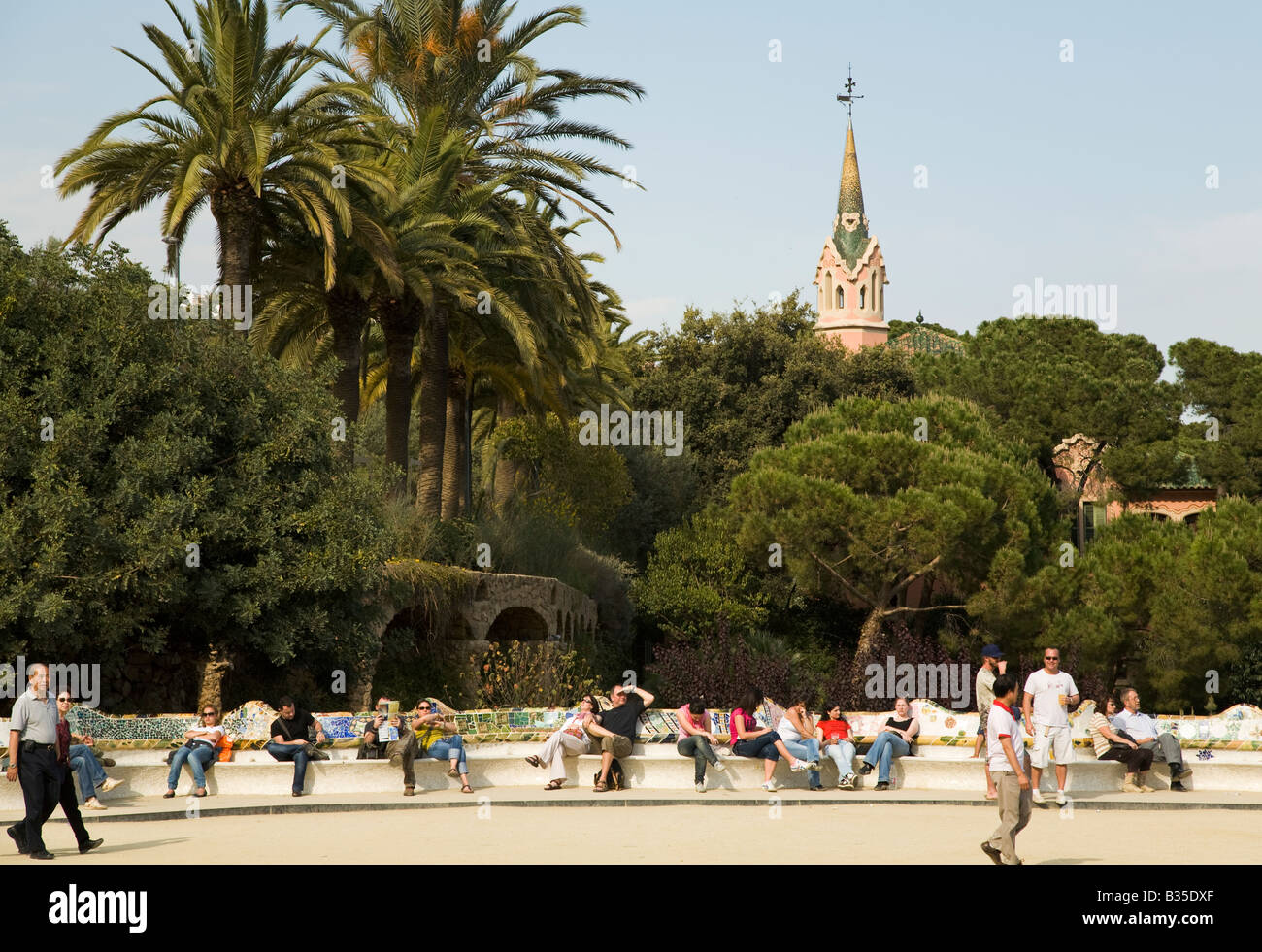SPAIN Barcelona People relax on curved bench in Parc Guell designed Antoni Gaudi architect Modernisme architecture Stock Photo
