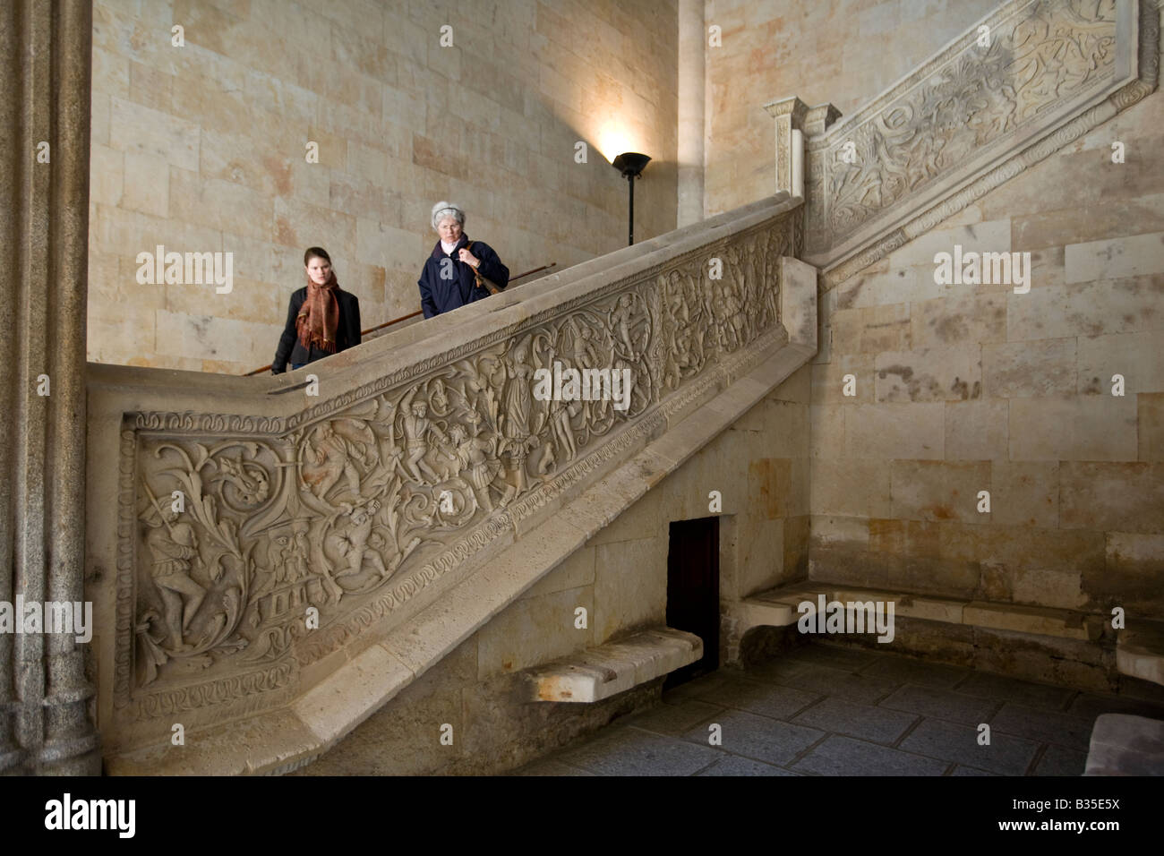 SPAIN Salamanca Two women descend staircase of the Historical Building at the University hermetic symbols carved into stone Stock Photo