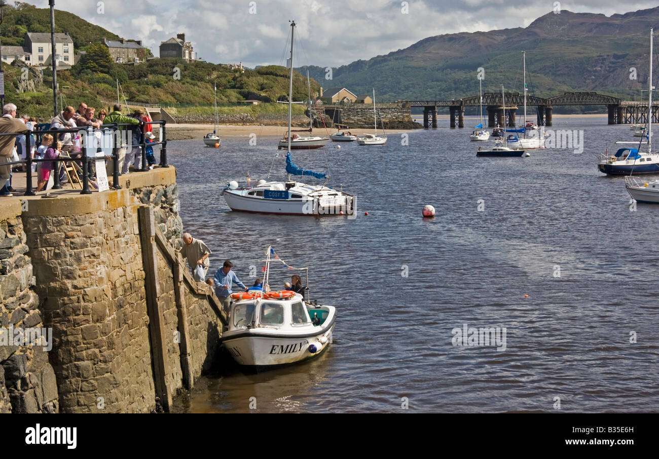 barmouth harbour mid wales showing passengers disembarking from small ferry boat Stock Photo