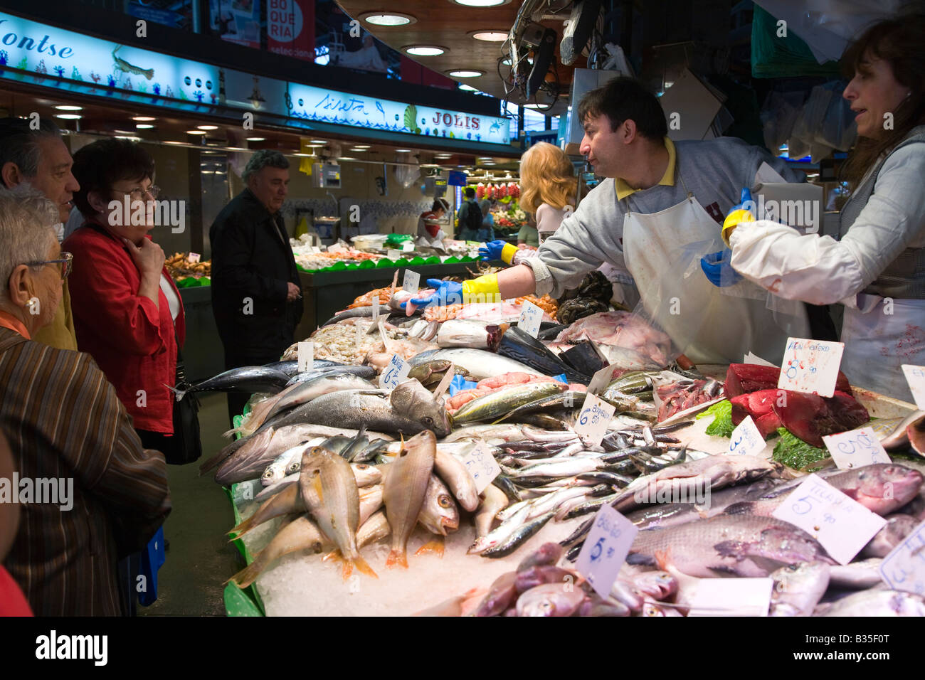 SPAIN Barcelona Fishmongers show fresh fish to customers in La Boqueria