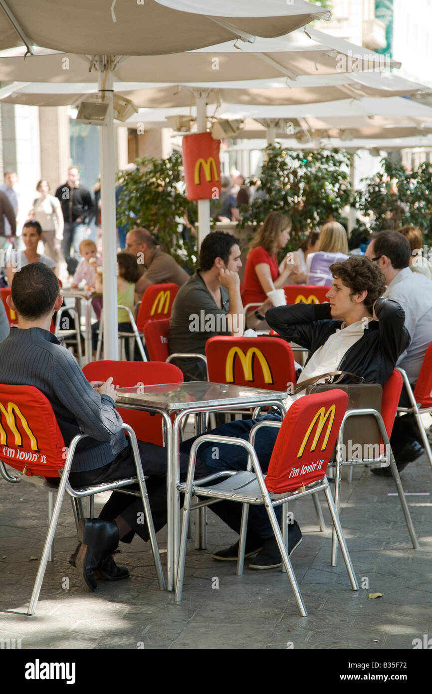 SPAIN Barcelona Customers sit at McDonalds umbrella tables on sidewalk of Passeig de Gracia Stock Photo
