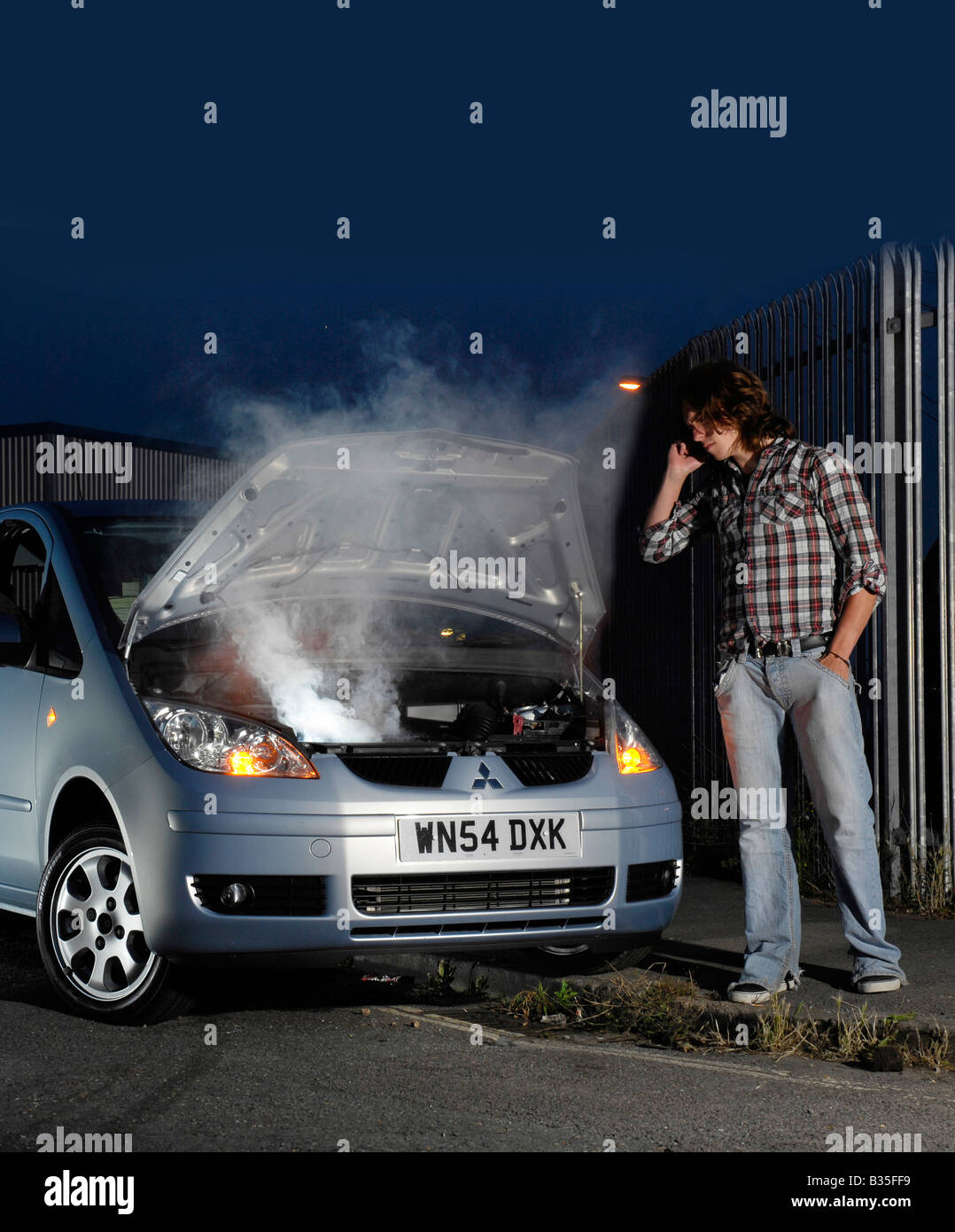 young man calling for help by his broken down car Stock Photo
