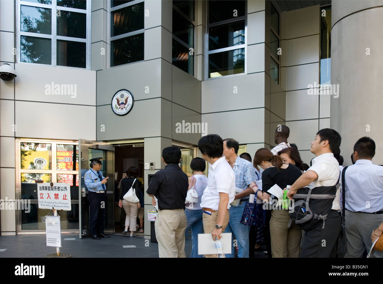 People standing in a queue at the United States of America Consulate General office in Osaka, Japan waiting to get a visa Stock Photo