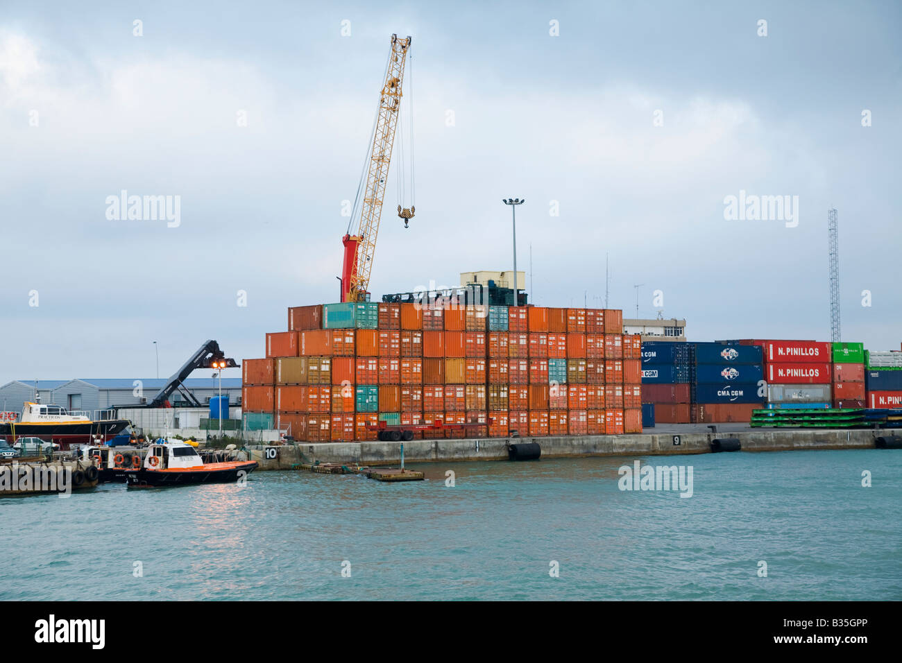 SPAIN Barcelona View from tour boat of harbor and waterfront shipping containers stacked cranes for unloading cargo from ships Stock Photo