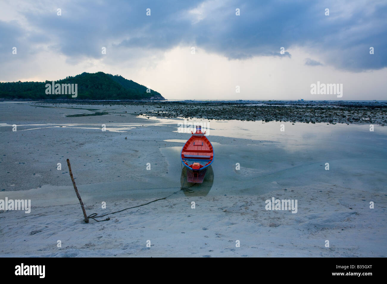 Traditional canoe between tides in village in Koh Penang, Thailand Stock Photo