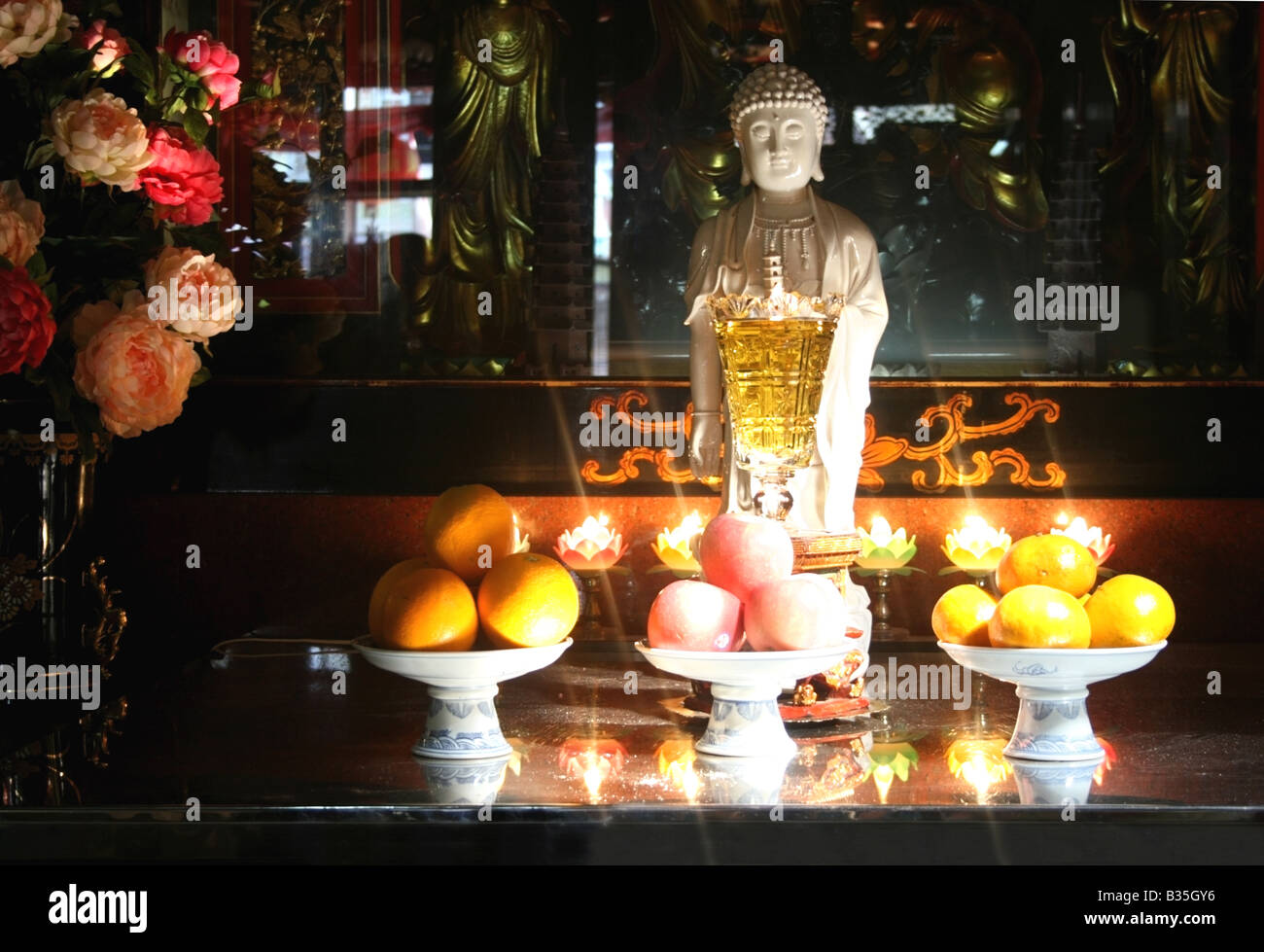 Statue of the taoist deity Kuan Yin, the goddess of mercy with fruit