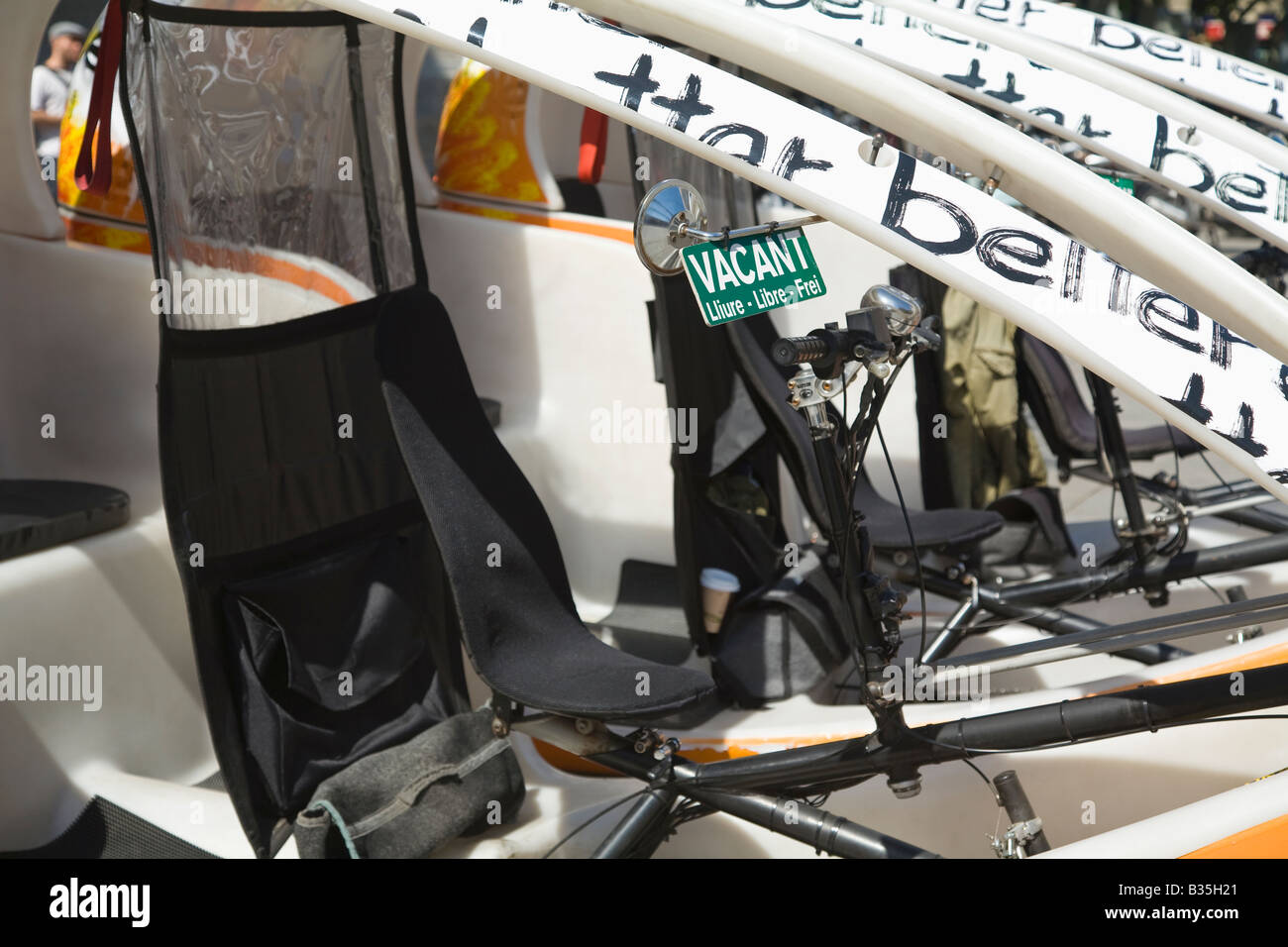 SPAIN Barcelona Bicycle taxis waiting to be rented sign in four languages Stock Photo