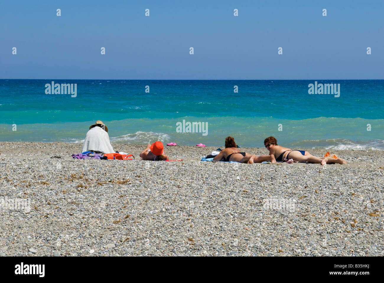 Holidaymakers relaxing on holiday by the edge of the sea at Rethymnon Stock Photo