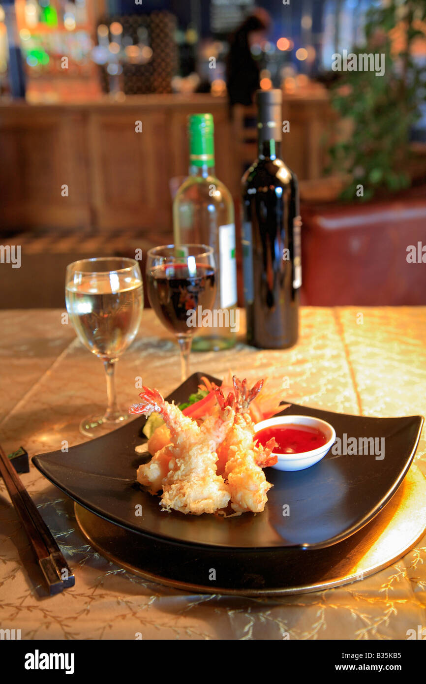 Deep Fried King Prawns Thai Food in a restaurant setting with White and Red Wine Stock Photo