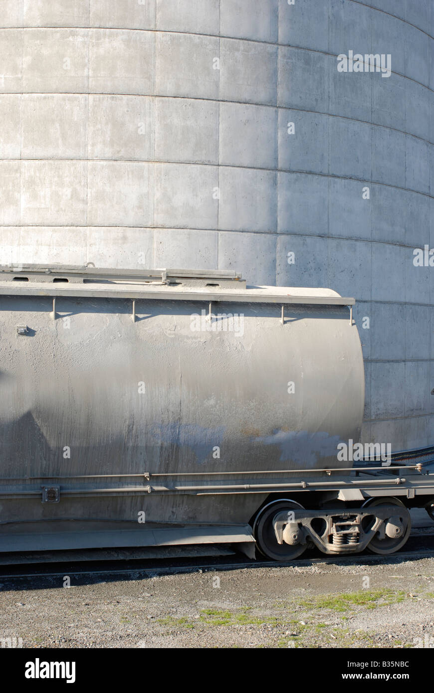 A rail wagon in front of silo at a cement production plant Stock Photo