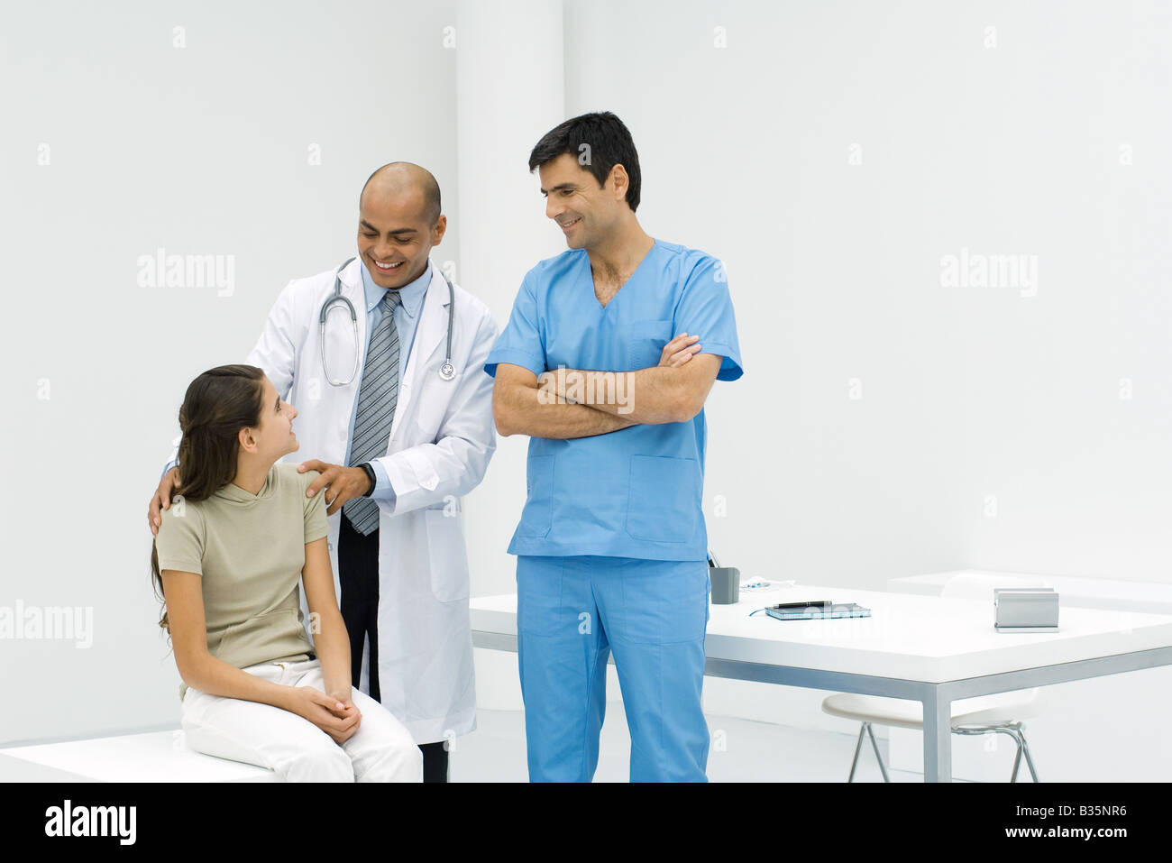 Doctor Standing With Hands On Teen Girl S Shoulders Male Nurse