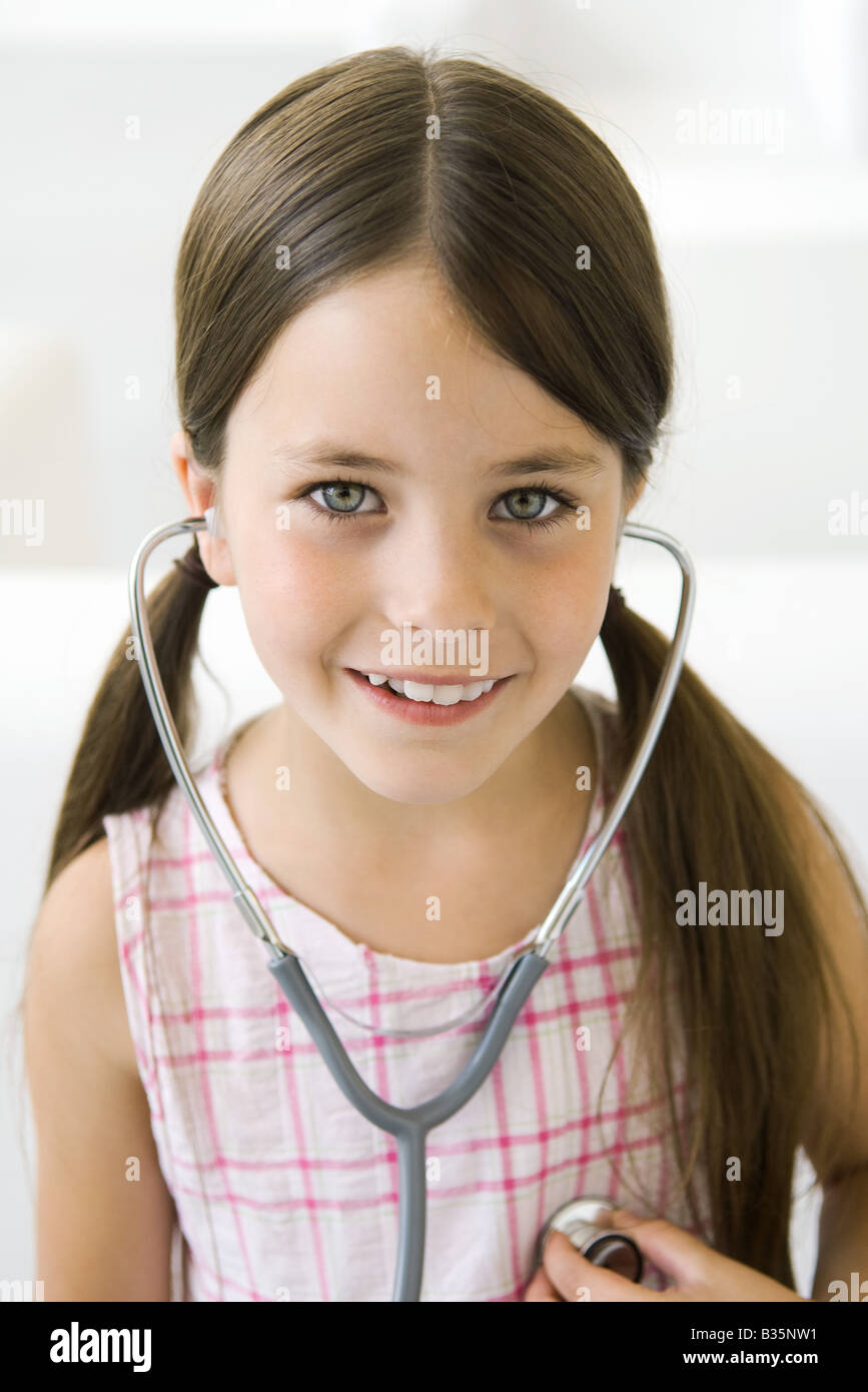 Girl listening to her own heart through stethoscope Stock Photo