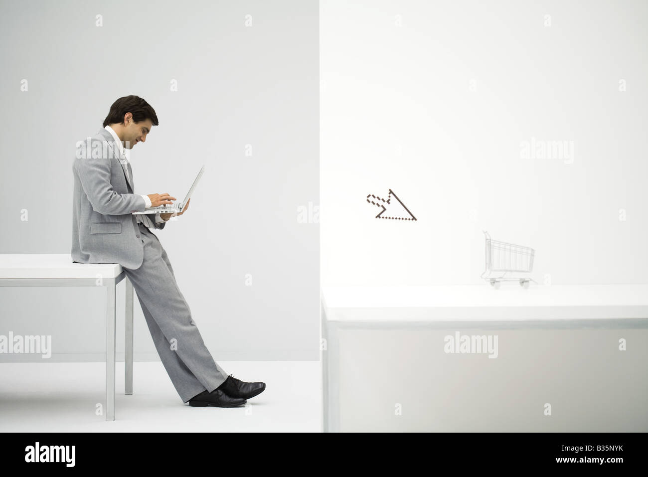 Businessman sitting on desk, shopping online, shopping cart and cursor