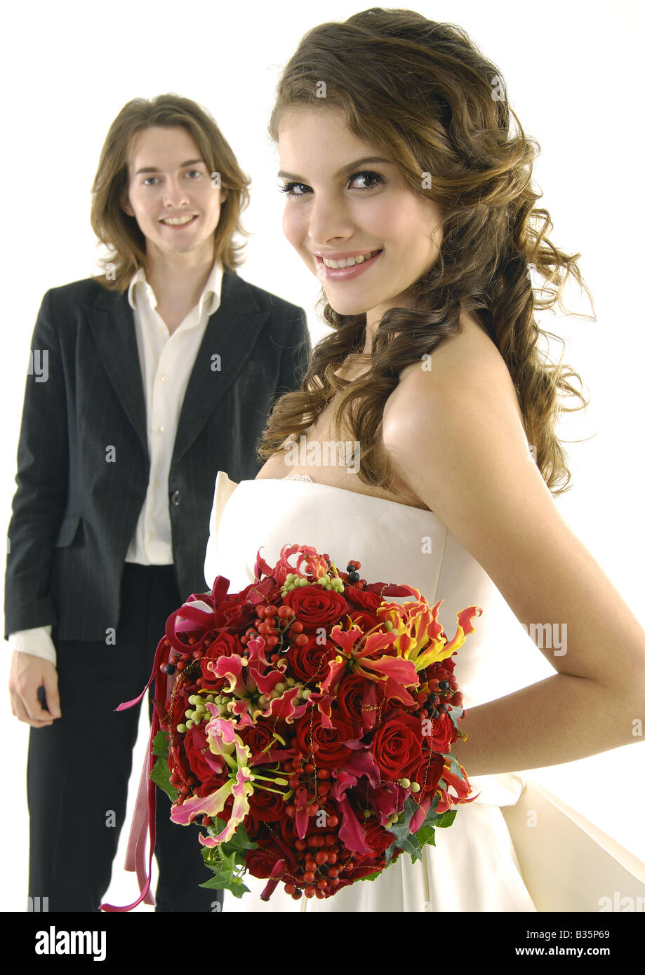 Portrait of a bride holding a bouquet of flowers with her groom ...